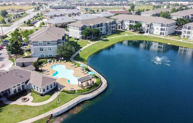 A large building with a pool and a pond in front.