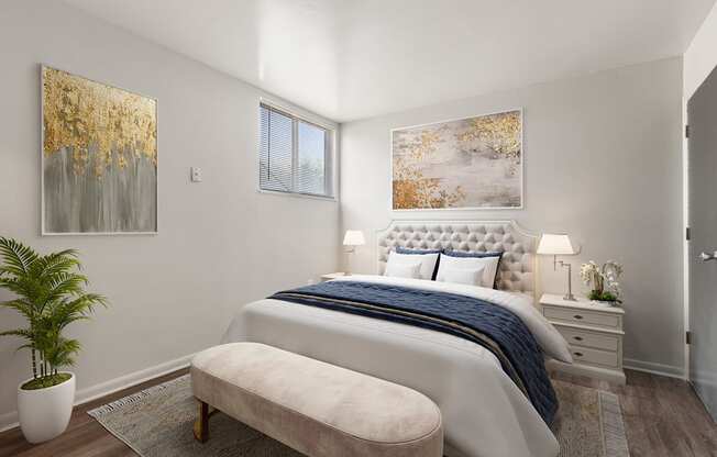 A bedroom with a large bed, a bench, and two framed pictures on the wall.