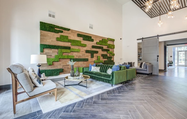 a living room with a green couch and a brick wall with moss on it at Century University City, Charlotte, NC