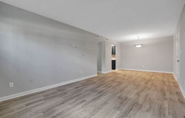 A room with wooden flooring and white walls.