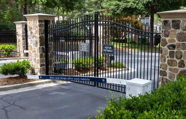 a gate with a stone wall and a mailbox in front of a cemetery