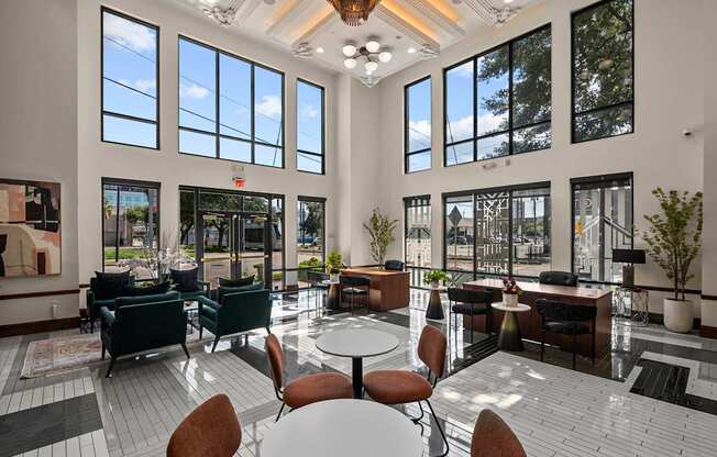 A large room with tables and chairs and a lot of windows.