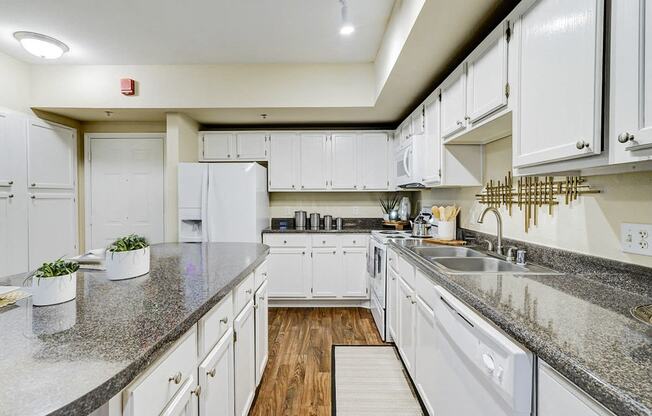 a kitchen with white cabinets and granite counter tops