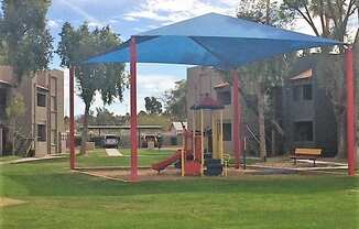 a playground with a blue canopy in a park