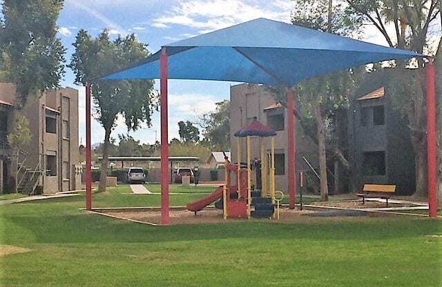 a playground with a blue canopy in a park