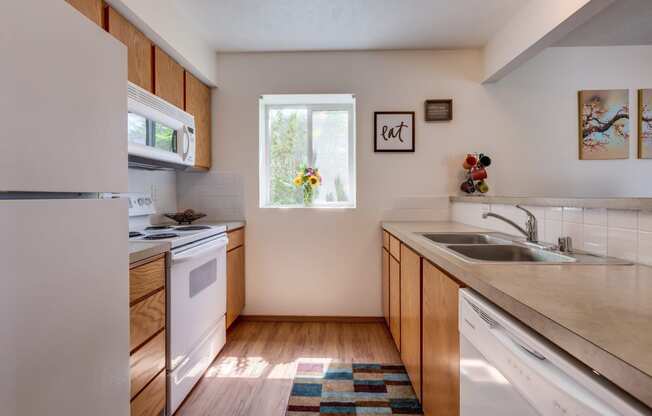 a kitchen with white appliances and wooden cabinets