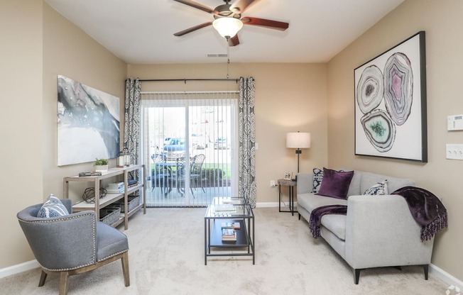 a living room with a ceiling fan and a sliding glass door