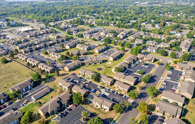 an aerial view of a neighborhood with cars parked in a parking lot
