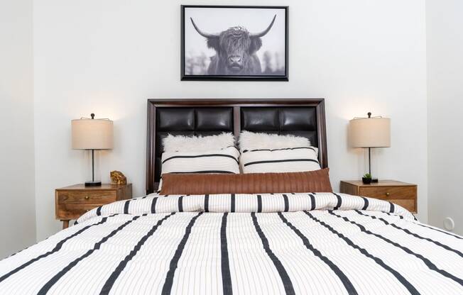 a bedroom with a bed and a picture of a bull on the wall