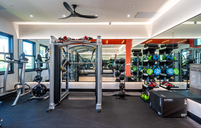 a gym with cardio equipment and weights on the wall