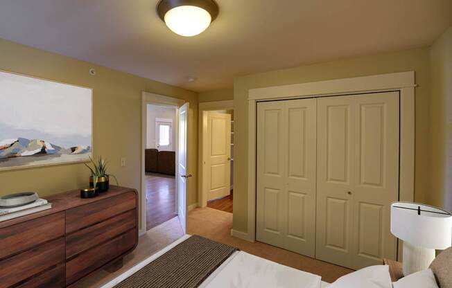 A bedroom with a bed, dresser, and a painting on the wall.