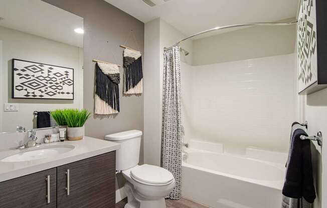 A bathroom with a white toilet, a white sink, and a white bathtub.