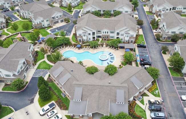 an aerial view of a community swimming pool surrounded by houses