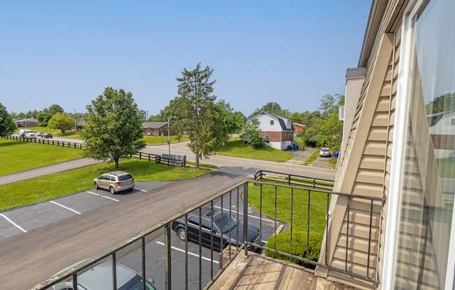 the view from the balcony of an apartment building with cars parked on the street