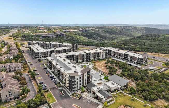 A large apartment complex with a parking lot in front.