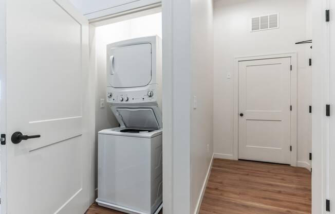 a small laundry room with a washer and dryer and a white door