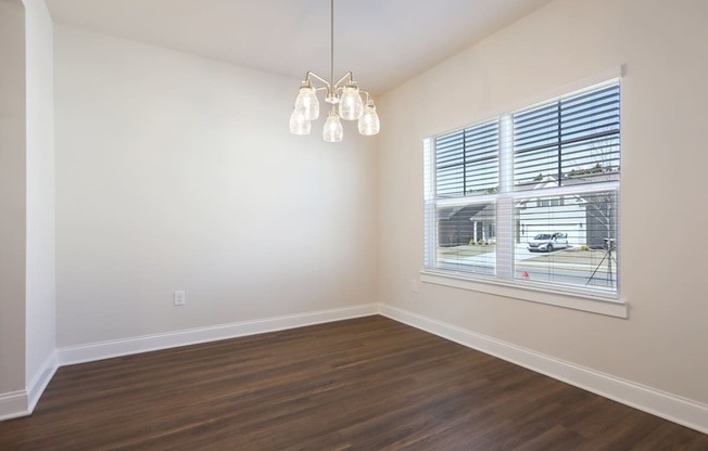 A room with a window and a wooden floor.