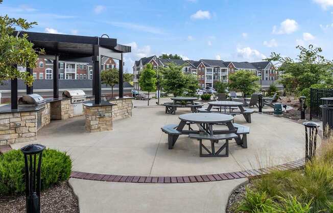 A sunny day at the outdoor picnic area with tables and benches.