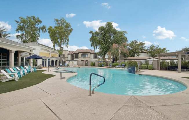 a swimming pool with chairs and a building in the background