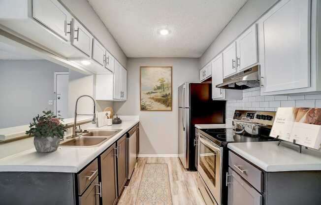 a kitchen with white cabinets and black appliances