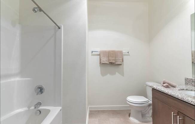 A white bathroom with a toilet, sink, and bathtub at Riverplace Apartment Homes, Oregon