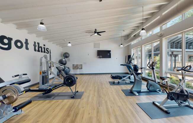 a gym with exercise machines and a tv