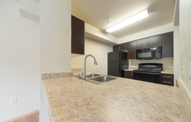 a kitchen with granite countertops and black appliances