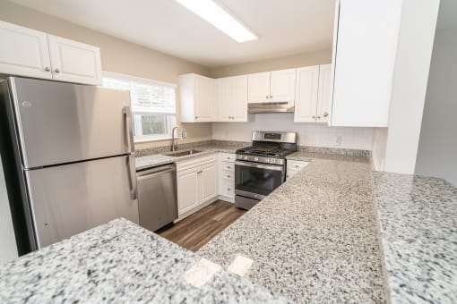 a kitchen with granite counter tops and stainless steel appliances at Merion Milford Apartment Homes, Milford, CT, 06460