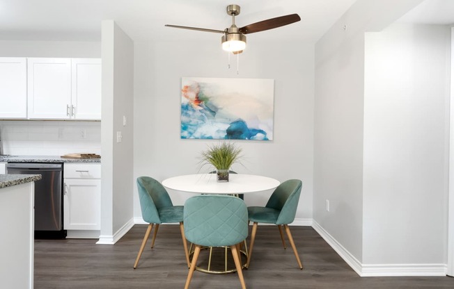 a dining room with a table and chairs and a ceiling fan