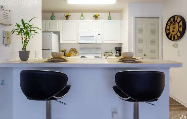 A kitchen with white cabinets and a white counter top.