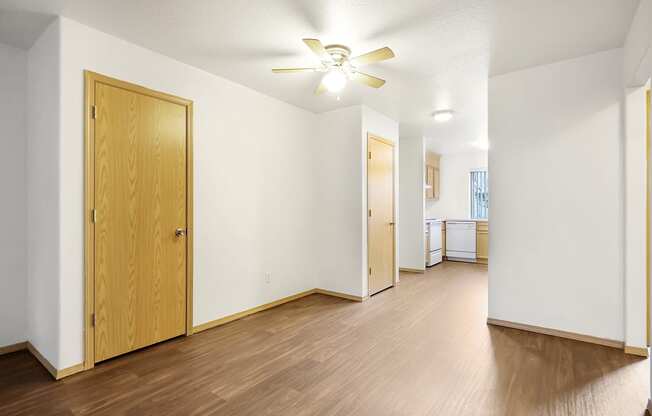 a living room with hardwood flooring and a ceiling fan