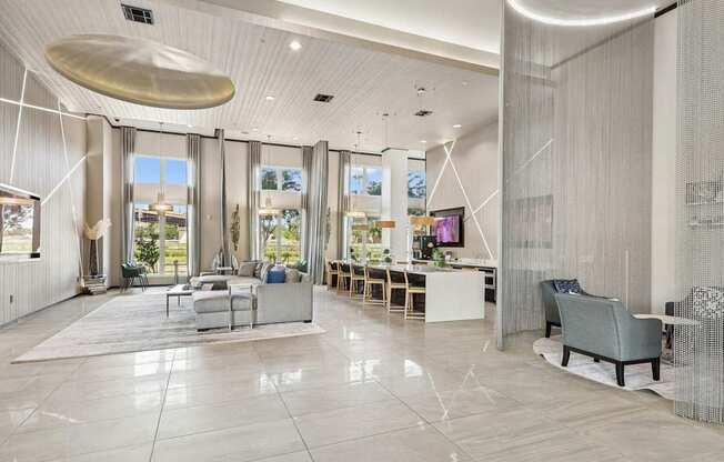 Spacious clubhouse with large windows, televisions, and couches at GreenVue Apartments in Richardson, TX
