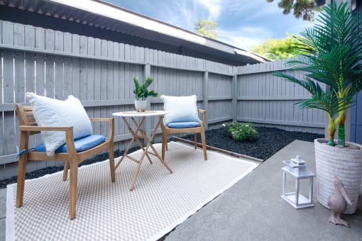 Model Apartment patio with two chairs and a table on a rug