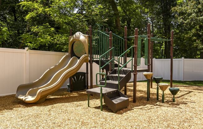 a playground with a slide and climbing equipment in a backyard