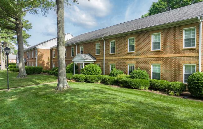 a large brick building with grass in front of a house