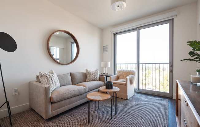 a living room with a couch and a door to a balcony