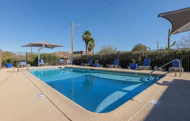A swimming pool with blue water and a white umbrella.