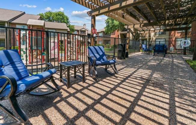 a patio with chairs and a pergola at the enclave at woodbridge apartments in sugar