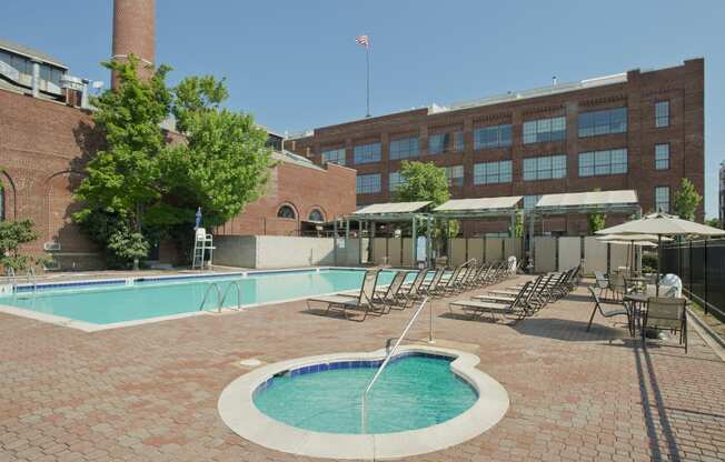 a swimming pool with chaise lounge chairs in front of a building at Tindeco Wharf, Maryland, 21224