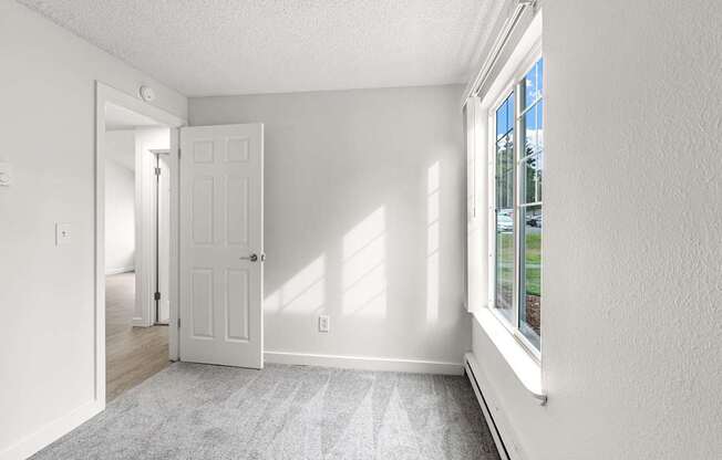 A white room with a door and a window.