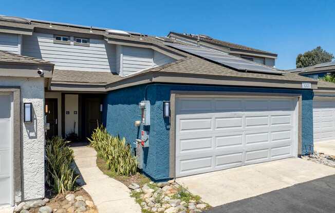 A blue townhome with an attached garage.