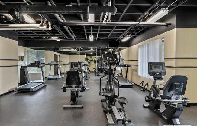 A gym with treadmills, elliptical machines, and other exercise equipment.