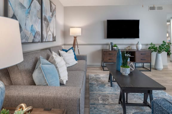 large living room with furnishings, decor, wall-mount TV, and  hardwood-inspired floors at Preserve at Cedar River Apartments, Jacksonville