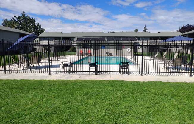 a swimming pool with a fence in front of a house