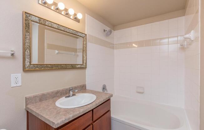 Bathroom with single sink, vanity, and shower/tub comboÂ 