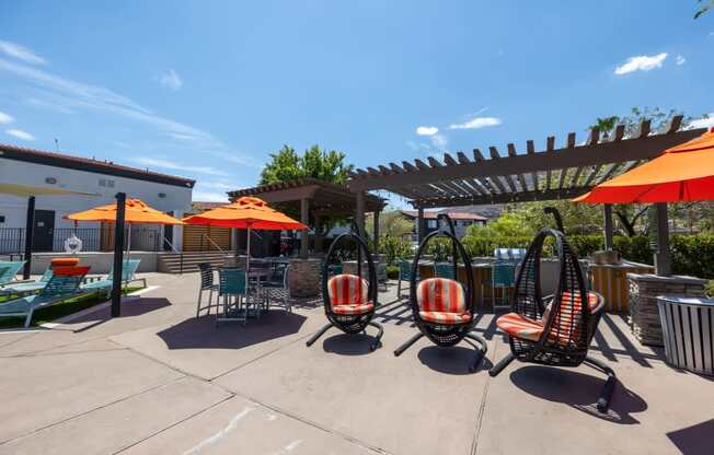 A patio with orange umbrellas and chairs.