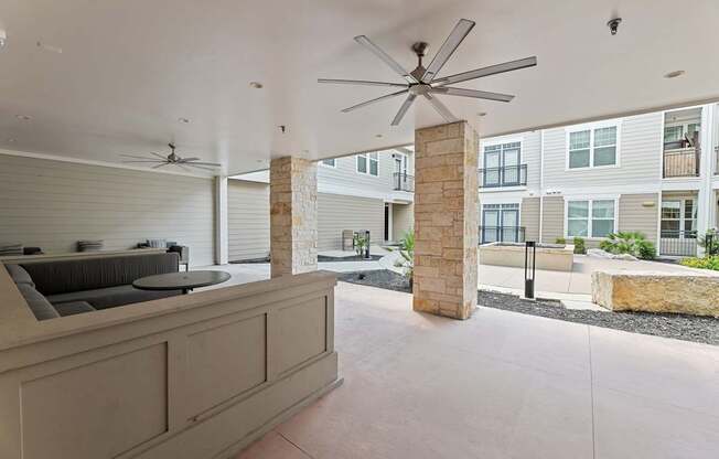 A modern outdoor kitchen area with a fan and a grill.