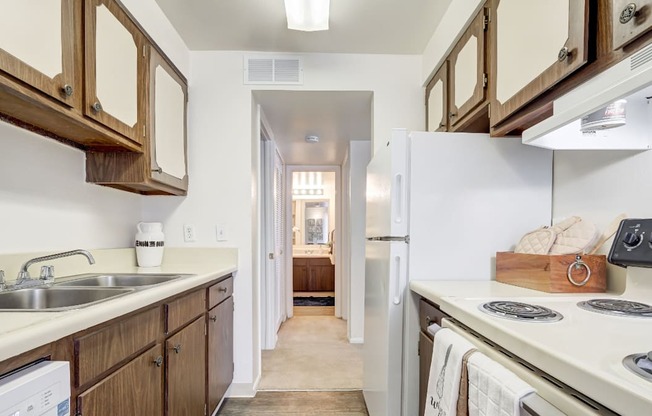 A kitchen with wooden cabinets and a white fridge.