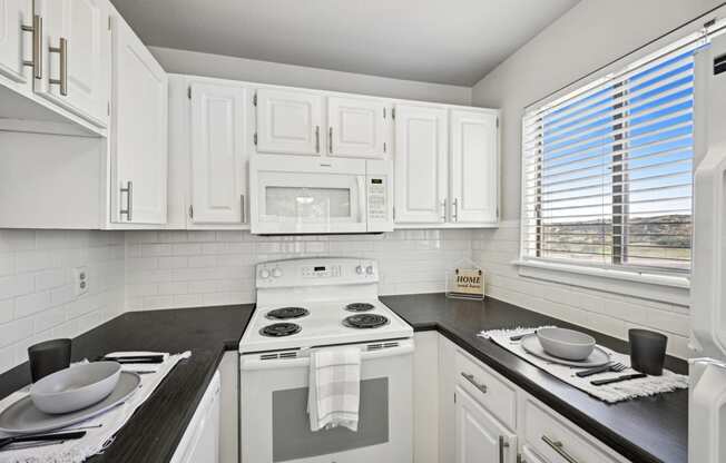 an empty kitchen with white cabinets and appliances