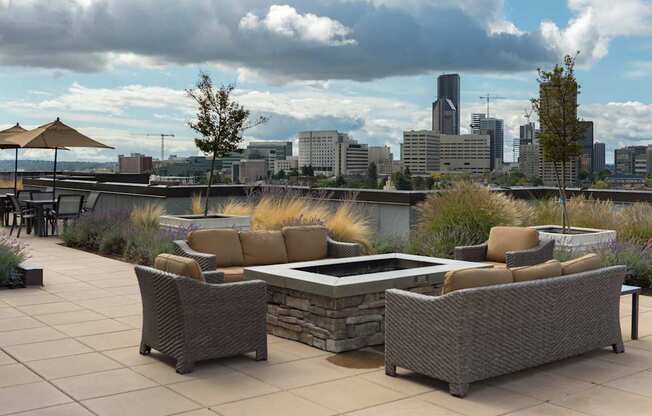 A patio with a table and chairs overlooking a city skyline.